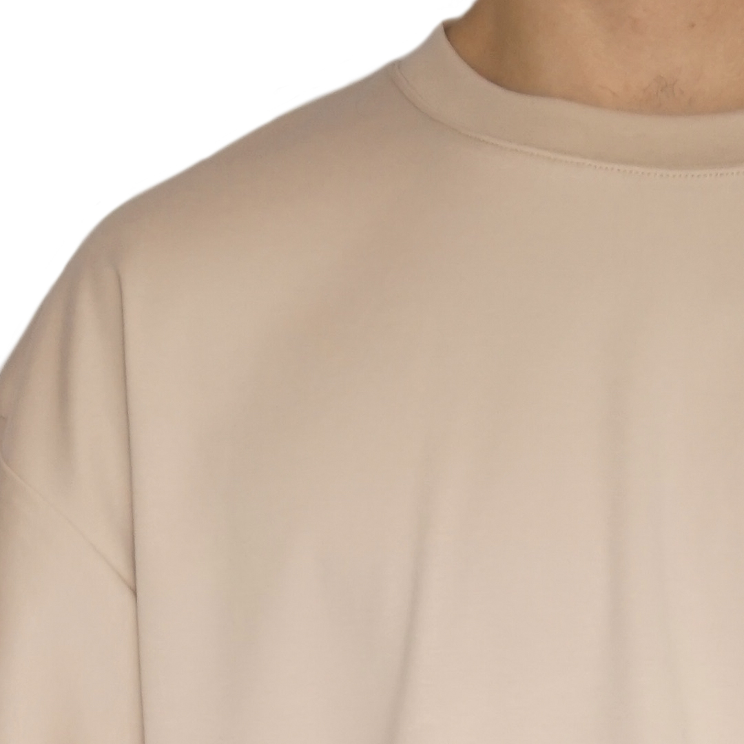 Detalle del cuello redondo de la polera oversize de algodón pima nude